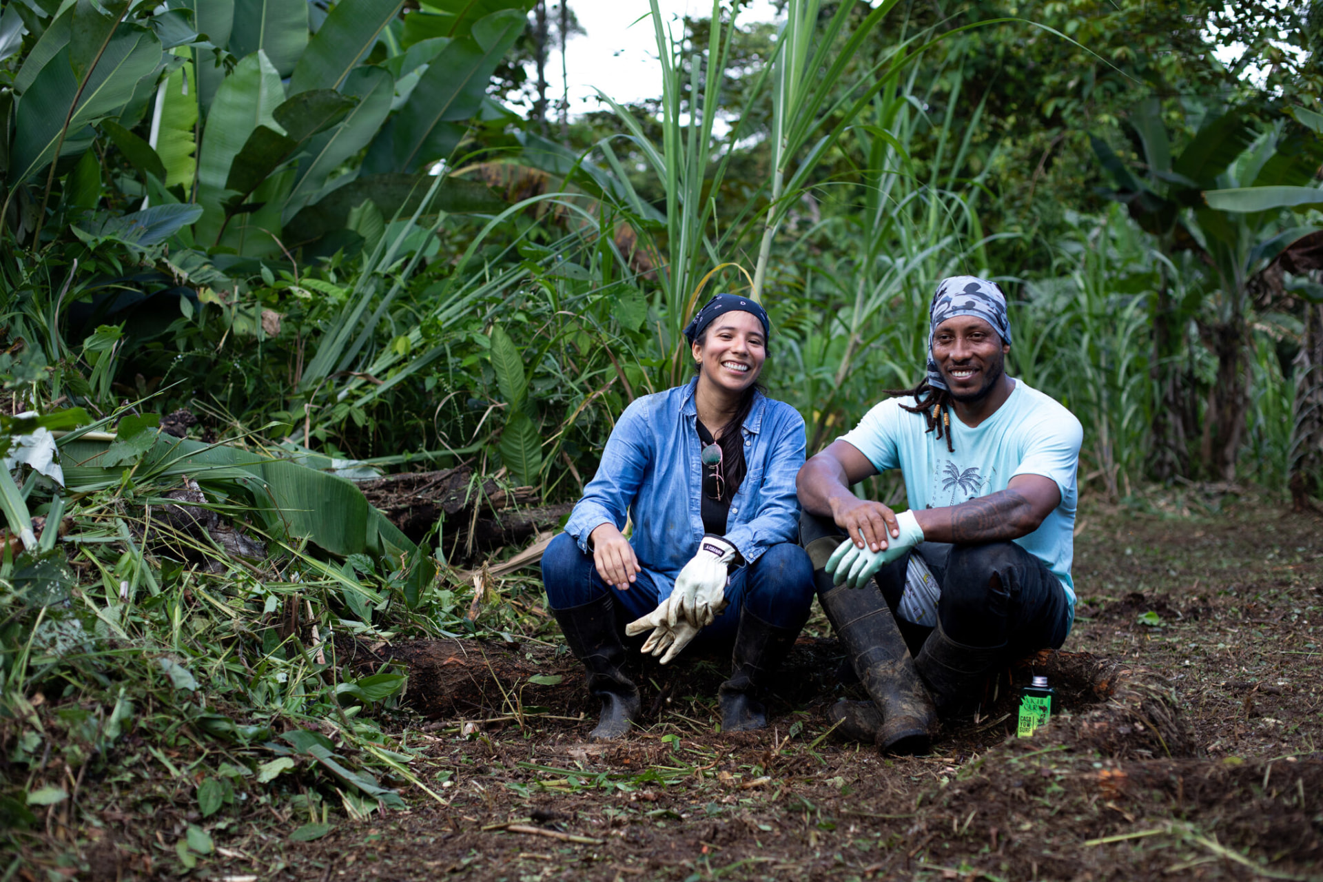 Yura Sapi and a colleague seated together in the forest garden of Protectores de la Tierra
