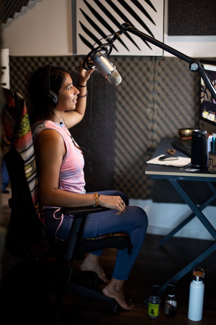 Yura Sapi recording in a studio, seated at a microphone
